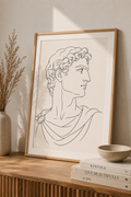 Apollo Fragment minimal line art print — framed classical Greek bust illustration in elegant line art style, displayed on a wooden sideboard, Morphē Studio

