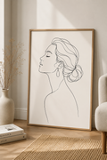 Elegant Muse minimal line art print — framed wall art leaning against a warm white wall in a Scandinavian living room with dried flowers and armchair, Morphē Studio
