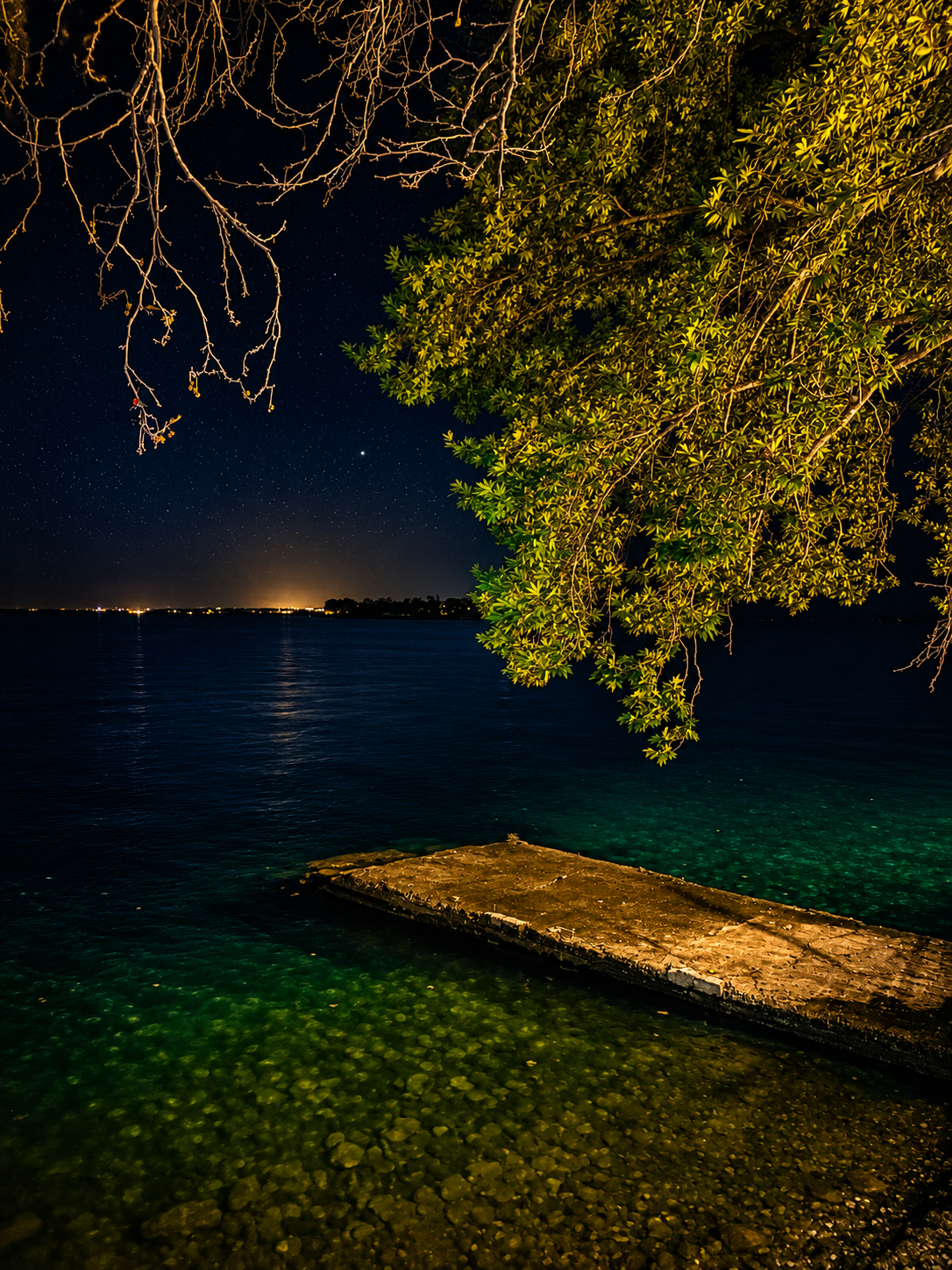 Cinematic midnight view of a pier on Lake Trichonida Greece – still waters reflecting stars under a deep blue night sky, wall art digital print by Morphē Studio
